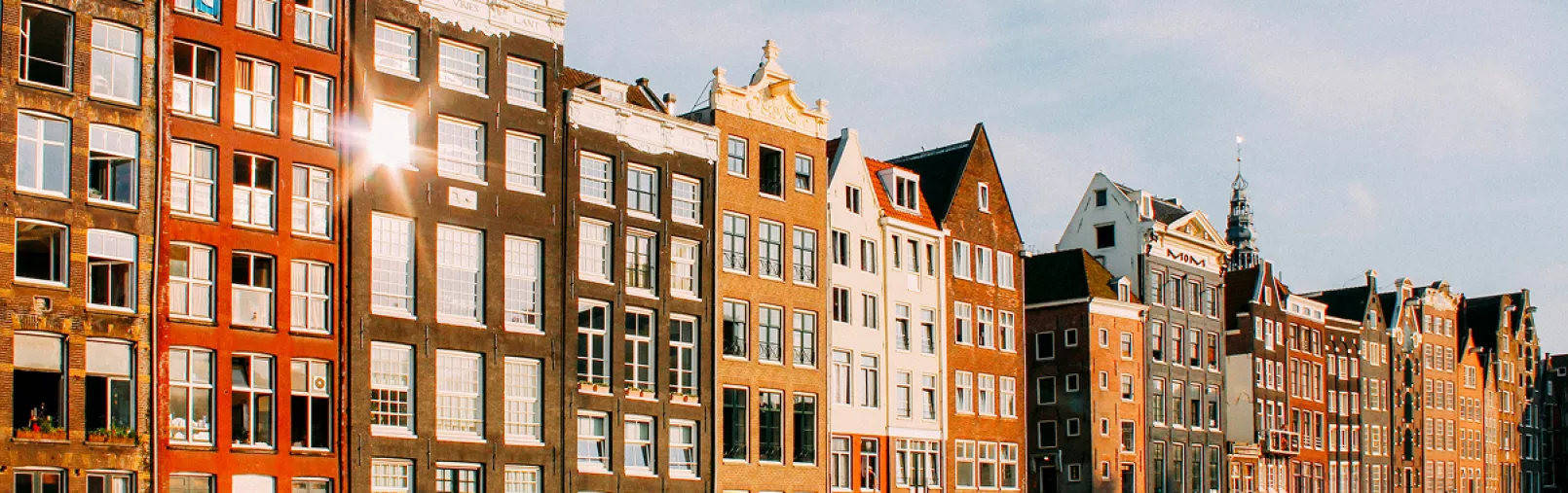 Row of traditional Dutch canal houses in Amsterdam illuminated by late-afternoon sunlight
