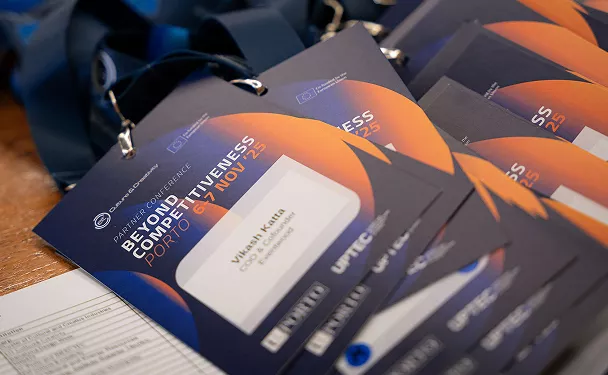 Close-up of conference name badges laid out on a table, featuring event branding and lanyards.
